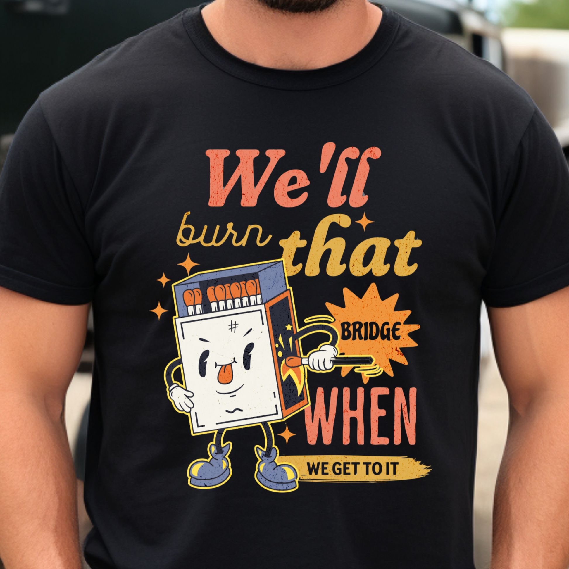 Funny matchbox graphic with the phrase "We’ll burn that bridge when we get to it" on a retro-style T-shirt, perfect for procrastinators and chaotic energy.